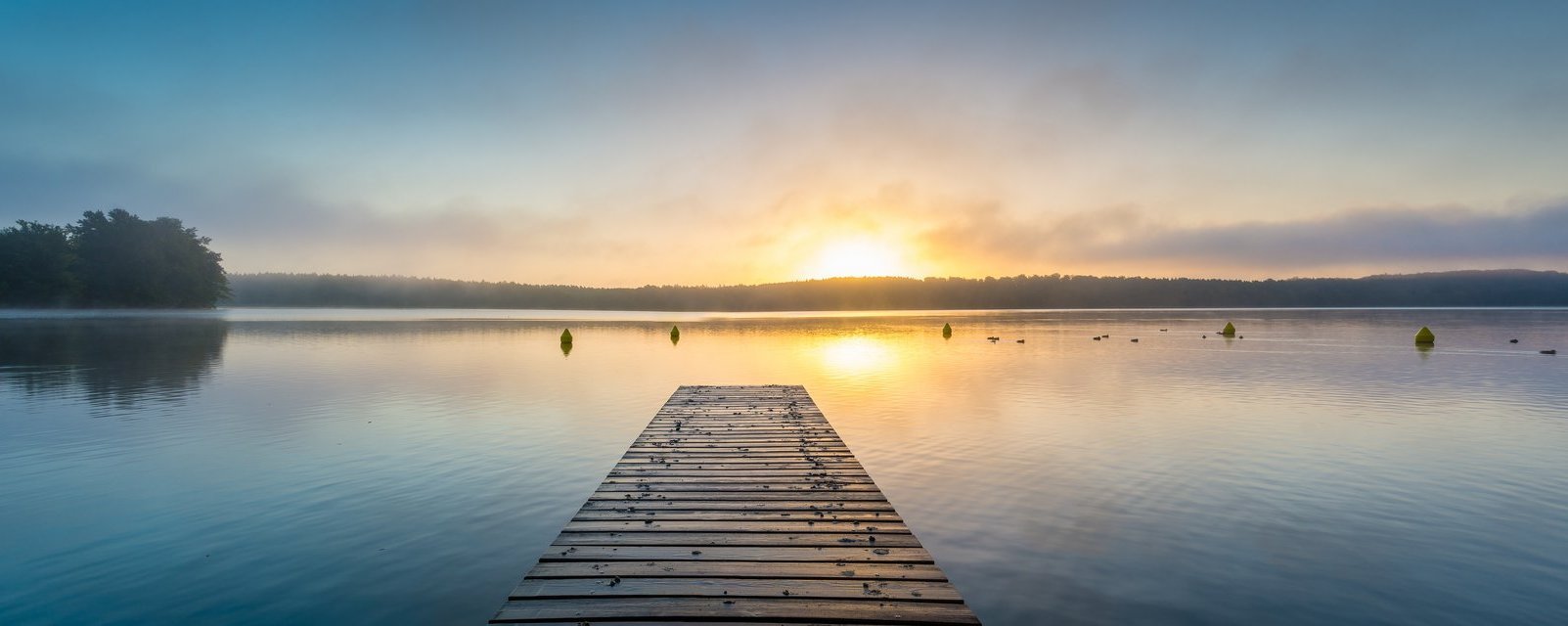 naturbild-seestimmung mit steg-sonnenspiegelung auf dem wasser